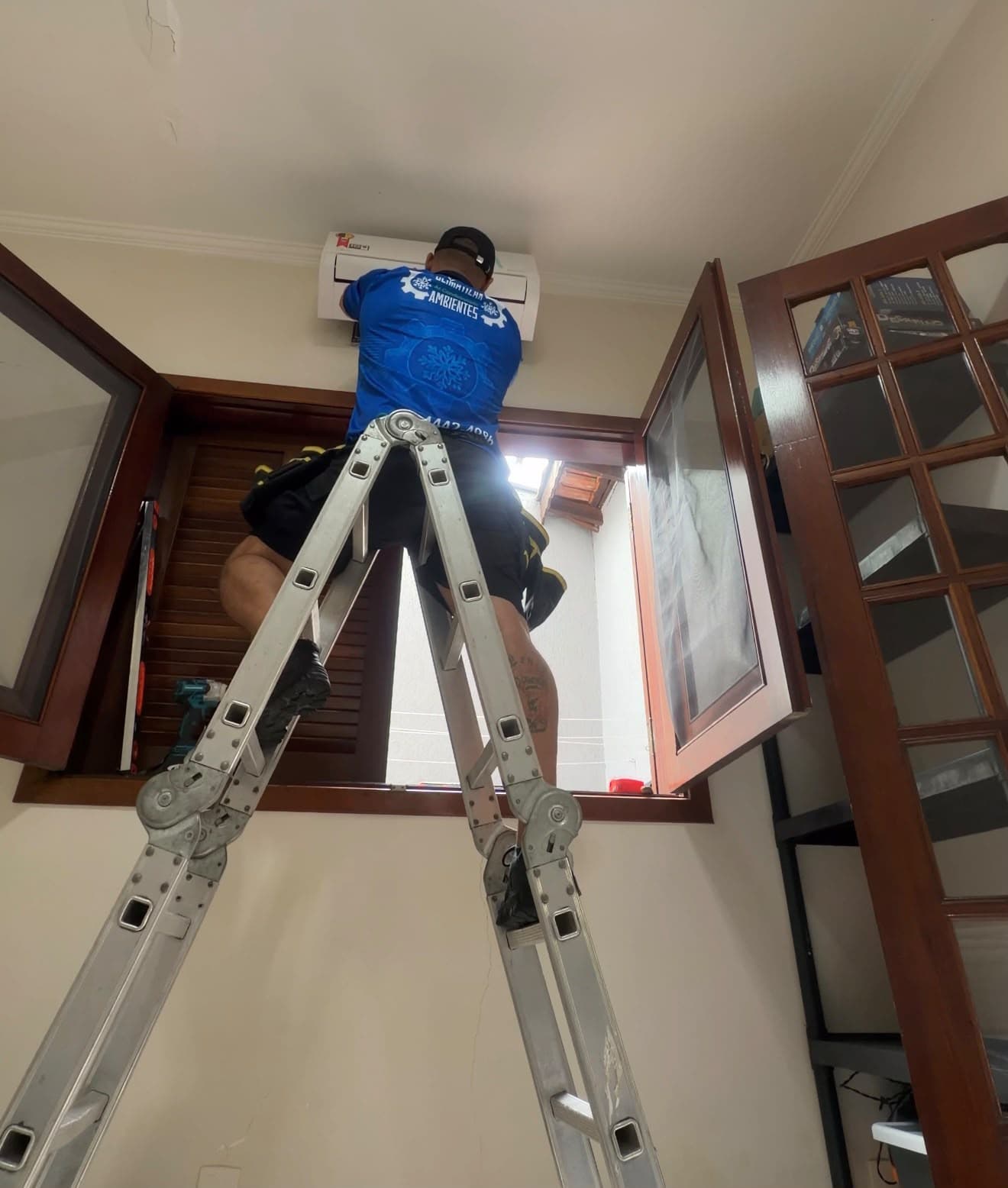 Técnico instalando unidade interna de ar-condicionado